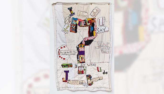 A large white wall hanging featuring a prominent piece of fabric, creating a minimalist and elegant decor element.