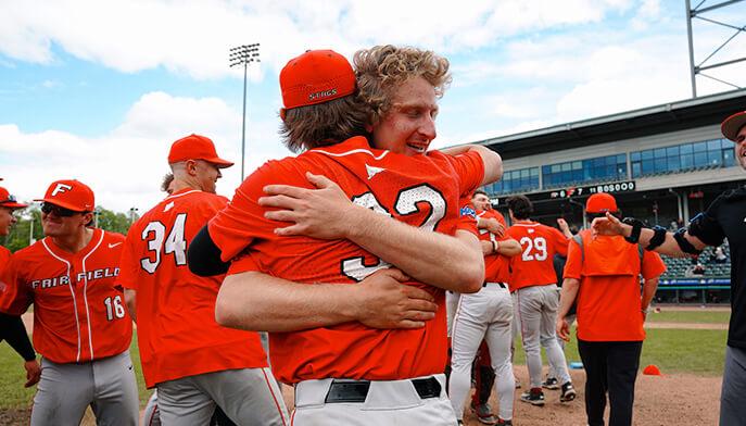 A group of baseball players joyfully hugging each other in celebration after a game. 