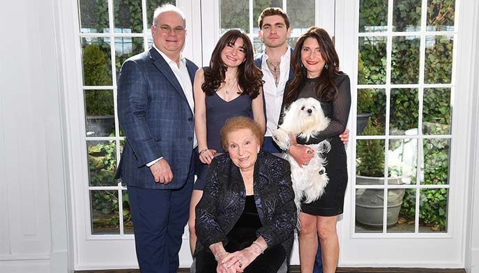 Image of The Santomero Family: Chris, Calista, Christopher ’26, Francesca (holding their family dog, Gio), and Lillian Sampino (seated).