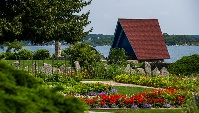 A quaint structure with a vibrant red roof, set in a serene environment.