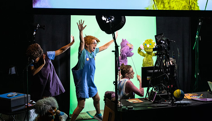 Several individuals stand in front of a green screen, likely preparing for a film or photography session.