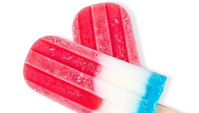 Close-up of two red, white, and blue popsicles with frosty surfaces. The bright colors and icy texture create a refreshing summer treat vibe.