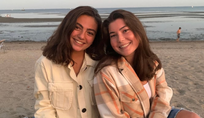 Image of two students on the beach