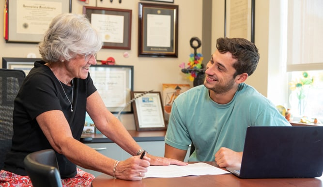 Student reviewing his resume with a career advisor