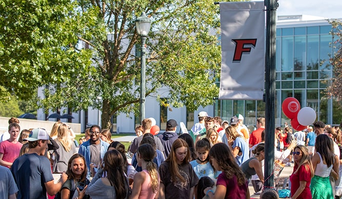 Students fill an outdoor space decorated with Fairfield balloons and banners.