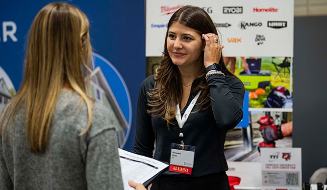 Current Fairfield student networking with an alumna at a career fair.
