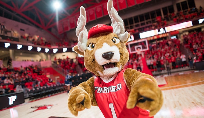 Fairfield's mascot, Lucas the Stag, pointing at the camera as he hypes the crowd up at the first men's basketball game of the season.