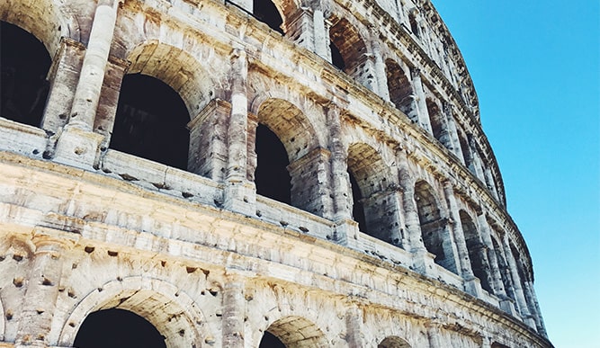 Closeup shot of the exterior of the Roman Colosseum on a clear, sunny day.