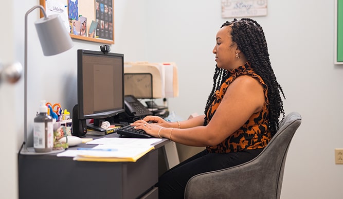 An older student completing work in an office as part of her federal work study.
