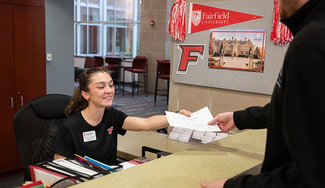 Student worker receiving a completed form in athe admissions office.