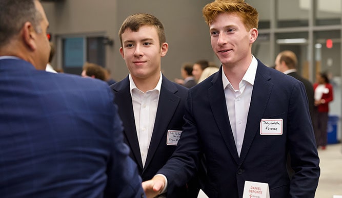 Business students connecting with a professional at one of Dolan's many networking events.