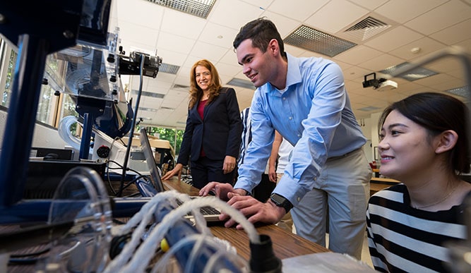 Students and professor working together on a mechanical engineering project.