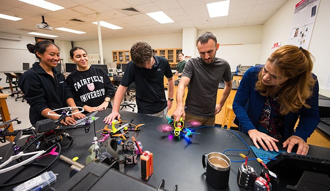 Professor Gigi Belfadel working together with students on programming and finessing a UAV drone.