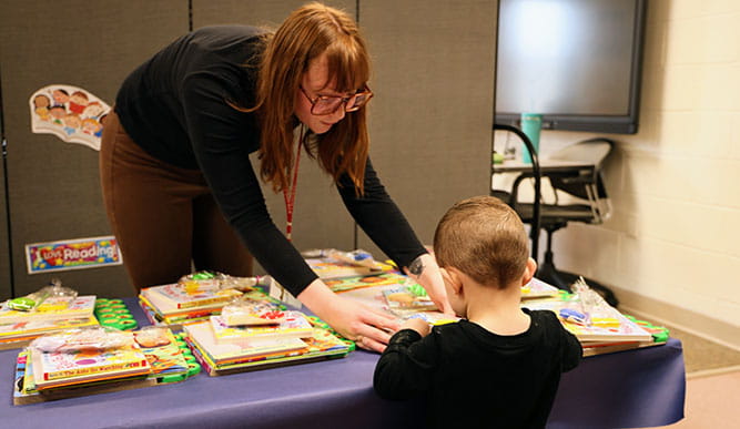 Collette Moreau distributing books to children at the Hall Neighborhood House Book Fair.