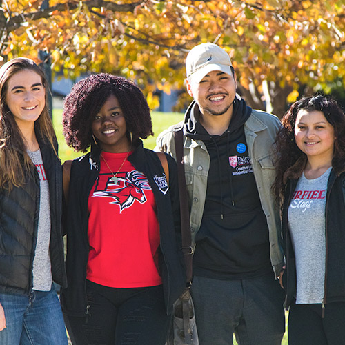 Four students walking around Fairfield University campus wearing Fairfield clothing