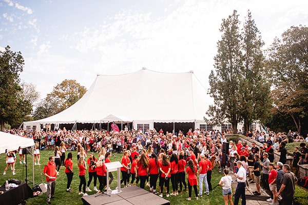 Fairfield University Alumni & Family Weekend 2021 attendees standing outside on the campus lawn near the AFW tent.