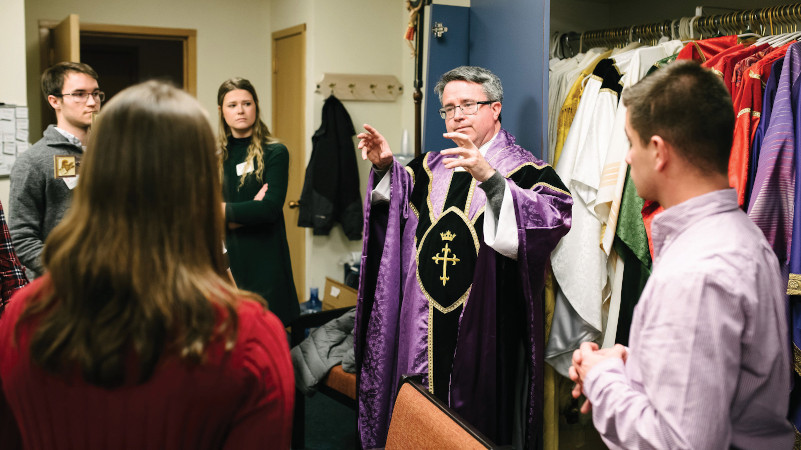 Student lectors and Eucharistic Ministers meet with Fr. Rourke in the sacristy, prior to Mass.