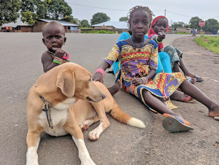 Local children play with 2017 alumna Bridget Mulkerin’s dog, Saï Saï