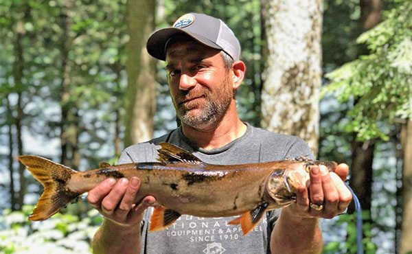 David DiCerbo ’97 holds a splake trout during an Adirondacks wilderness adventure.