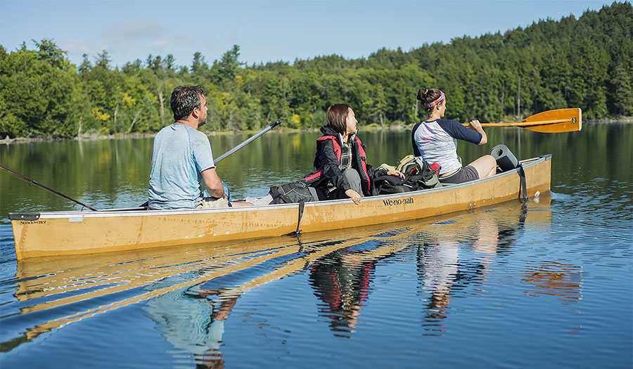DiCerbo and Tackett canoe with a client in the Adirondack wilderness.