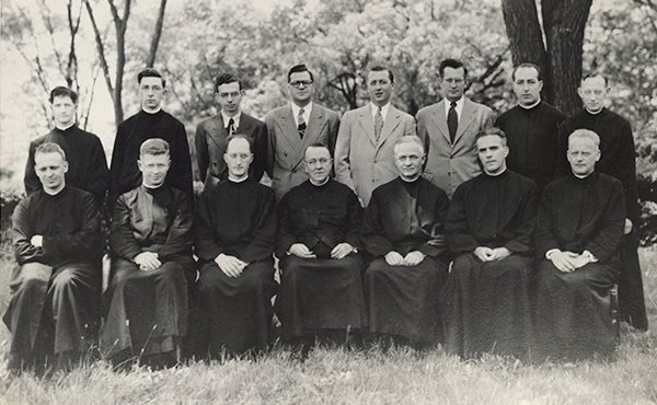 Group portrait of the first faculty of Fairfield University, 1947–1948. Front row, (l-r): Rev. Francis C. Buck, S.J.; Rev. Robert B. MacDonnell, S.J.; Rev. Laurence C. Langguth, S.J.; Fairfield University President Rev. James H. Dolan, S.J.; Rev. Vincent A. Gookin, S.J.; Rev. Arthur A. MacGillivray, S.J; Rev. James A. Walsh, S.J. Back row: Rev. Victor F. Leeber, S.J.; Rev. James T. Creamer, S.J.; Mr. Arthur R. Riel, Jr.; Mr. Carmen F. Donnarumma; Mr. John F. Cody; Mr. Chester J. Stuart; Rev. Frederick A. Harkins; Rev. John P. Murray, S.J.