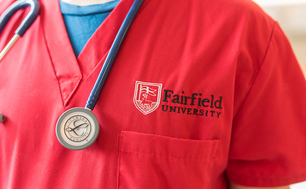 A close up of a student wearing a red Fairfield University shirt
