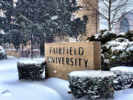 Photo of a snow covered Fairfield University sign.