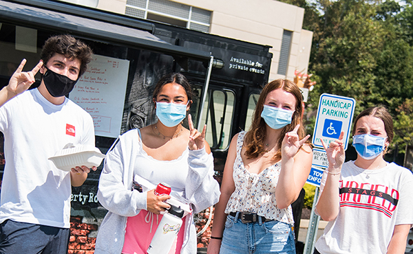 Fairfield University students at a food truck on campus (with masks on)