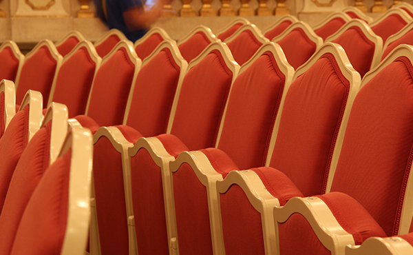 A few rows of empty orange theater seats