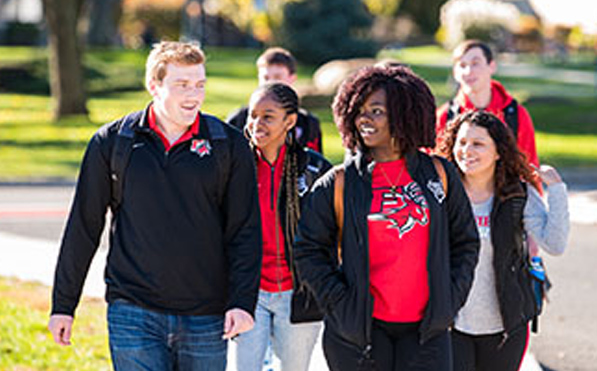 A group of students walking through campus with a student wearing Legacy F-Stag Logo shirt