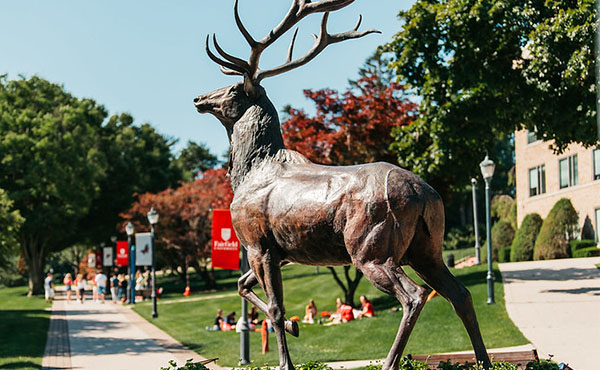 A sunny day on Fairfield University campus with Stag Statue in forefront 