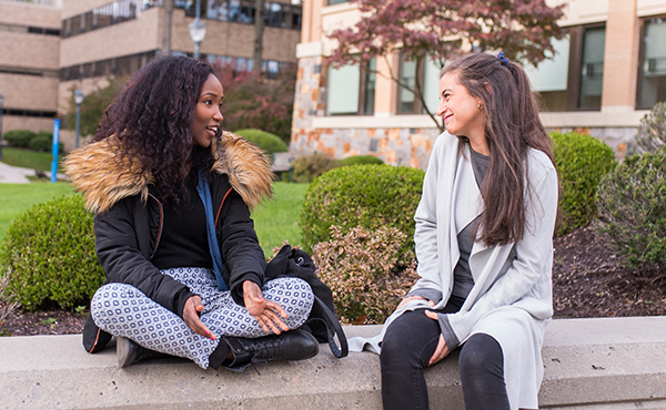 Image of students talking outside of the the DiMenna-Nyselius Library.