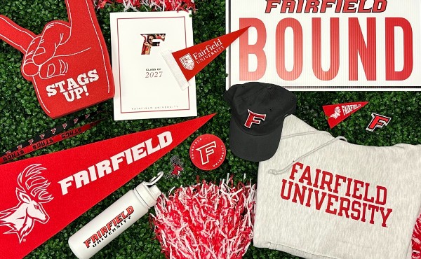 Assortment of Fairfield University gear spread-out on grassy background.
