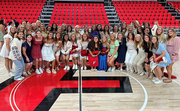 Group photo of student athletes at center court inside the Leo D. Mahoney Arena.
