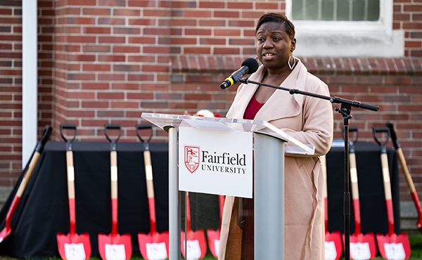 Nakia Létang speaking at a podium during a Fairfield University event.