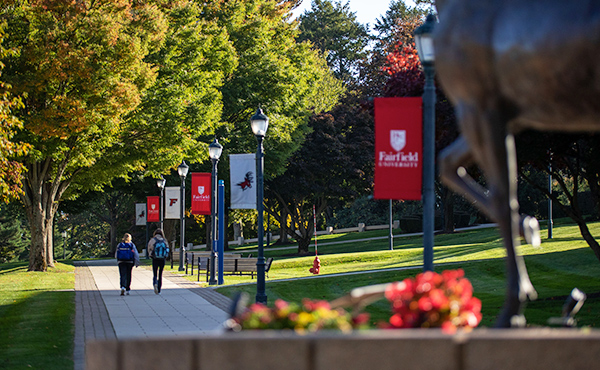 Photo of Fairfield University campus showing walkway and red and white banners.