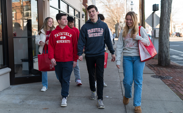 Students walking around downtown Fairfield wearing Fairfield University gear.