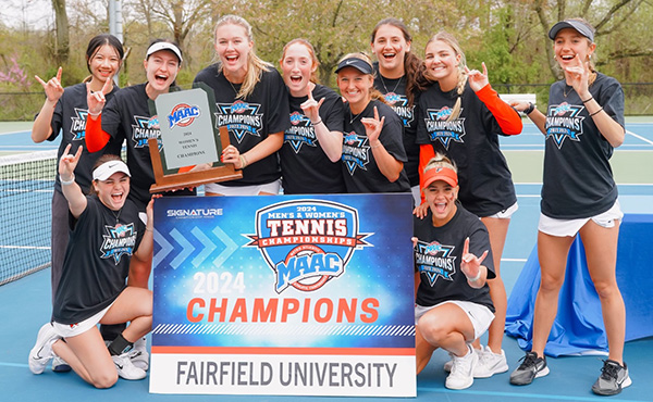 Group shot of women's tennis team celebrating their 2024 MAAC Championship with trophy.