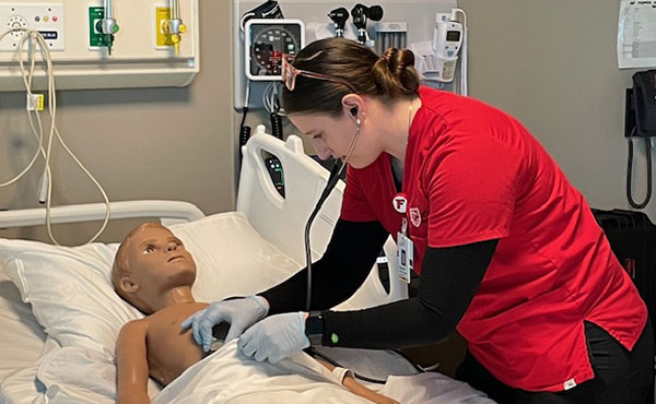 Student Gabby Kearney ’24 assesses a patient during a pediatrics simulation.