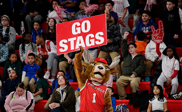 Lucas the Stag at Kids' Day Out 2023 holding a red sign with one arm over his head that reads: Go Stags.