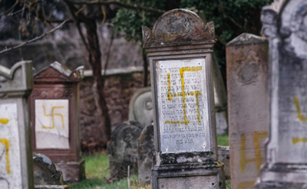 Gravestones graffitied with swastikas. 