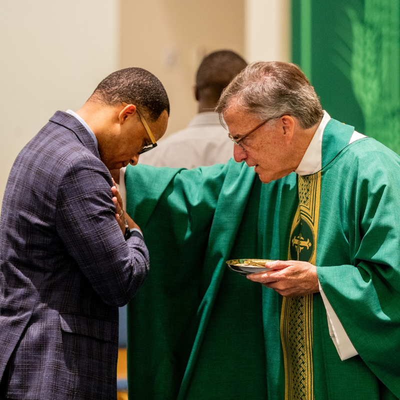 One of the Jesuits blessing an attendee at Daily Mass.