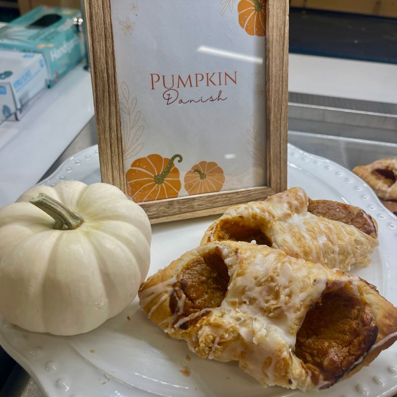 A display stand with pumpkin danishes and a Pumpkin Danish sign 